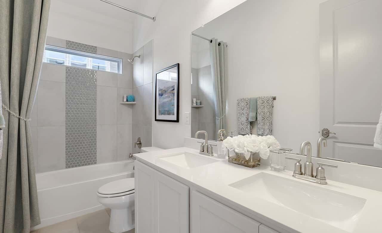 Elegant bathroom with dual sinks, tiled shower in Thompson Farms community.