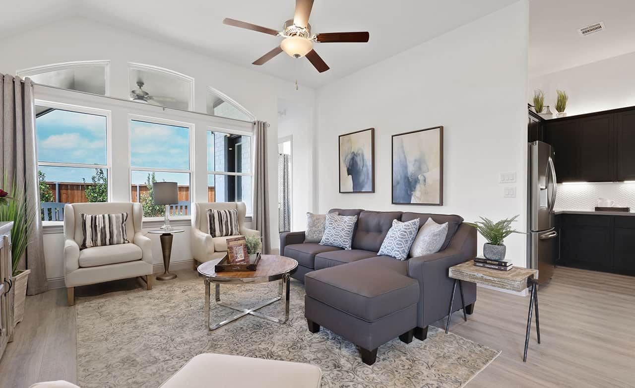 Elegant living room with vaulted ceiling, large windows, and modern decor, Thompson Farms community.