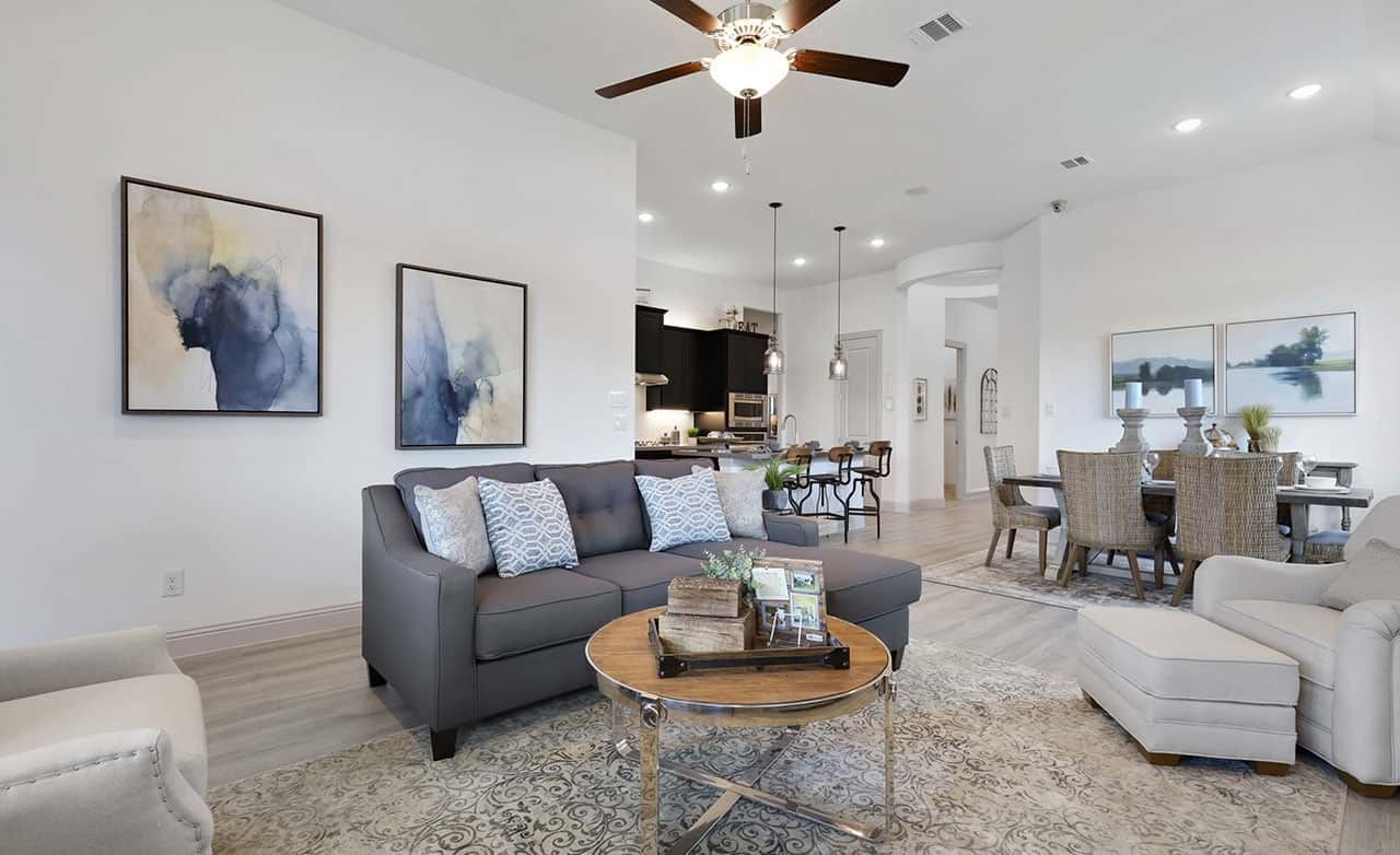 Modern living room with neutral tones, stylish furniture, elegant decor in Thompson Farms community. High ceiling.