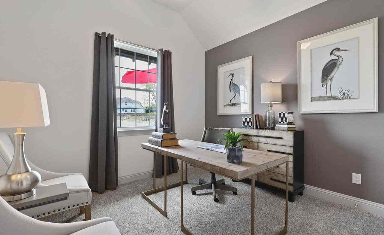 Elegant home office in Thompson Farms with wood desk, heron art, and natural light from large window.