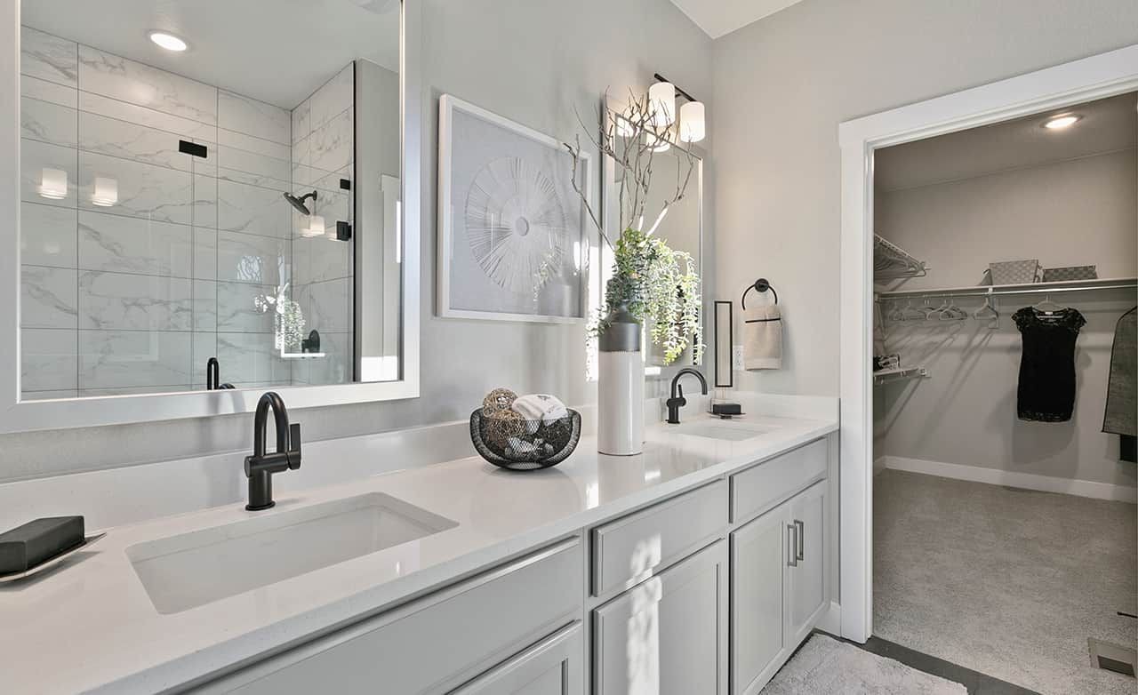 Modern bathroom with marble shower, dual sinks, walk-in closet in Trailside on Harmony community.