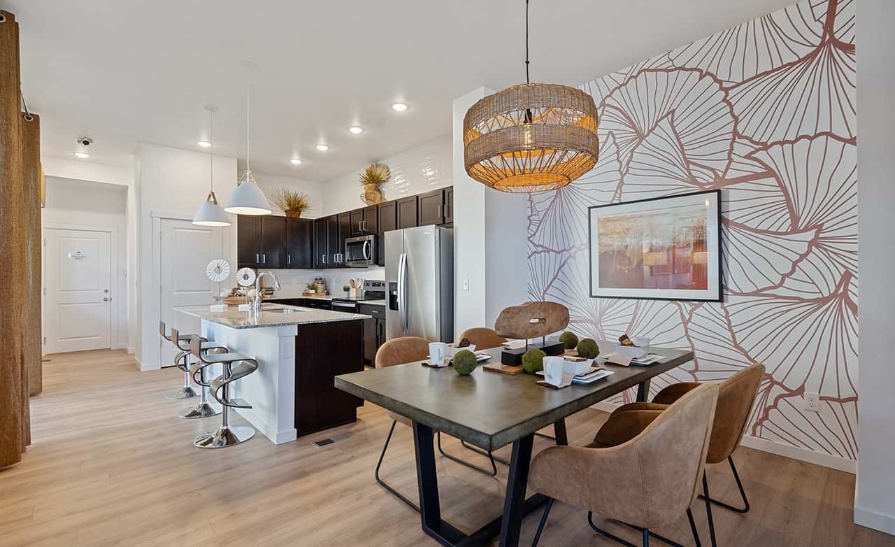 Modern kitchen and dining area with island, pendant lights, and unique floral accent wall, Trailside on Harmony.
